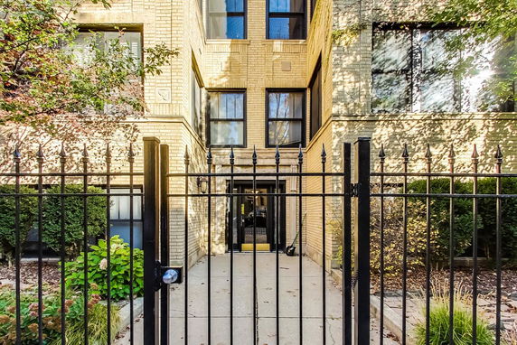 Front view of a multi-story building with a gated entrance.