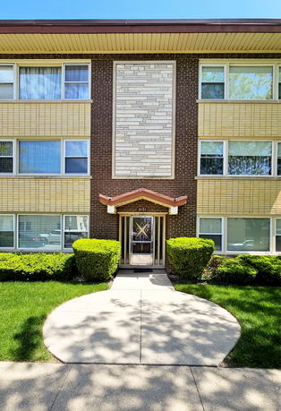 Front view of a multi-story brick building with a central entrance.