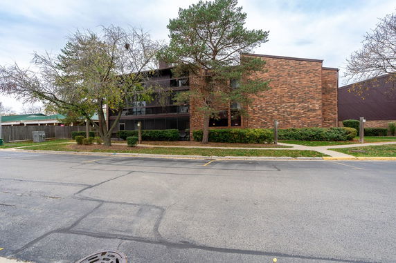 Front view of a brick multi-story apartment building.