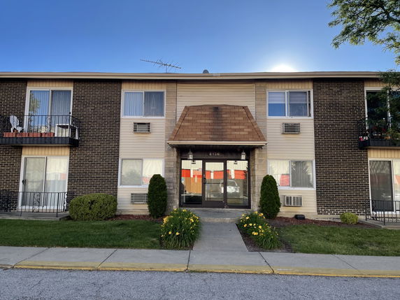 Front view of a two-story apartment building with balconies.