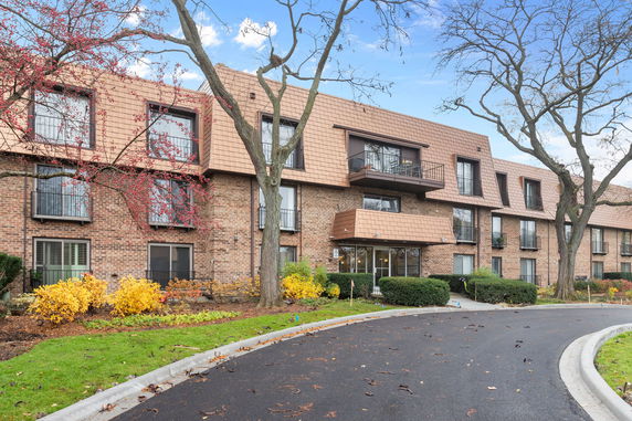 Front view of a multi-story building with brick facade and balconies.