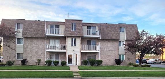 Front view of a multi-story apartment building with balconies.