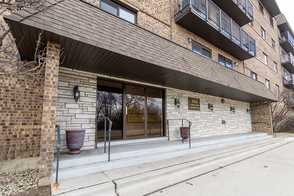 Front view of a multi-story condominium building with brick facade and balconies.