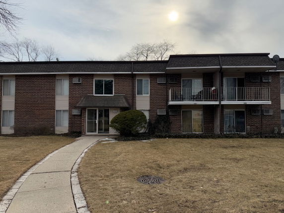 Front view of a two-story apartment building with balconies.