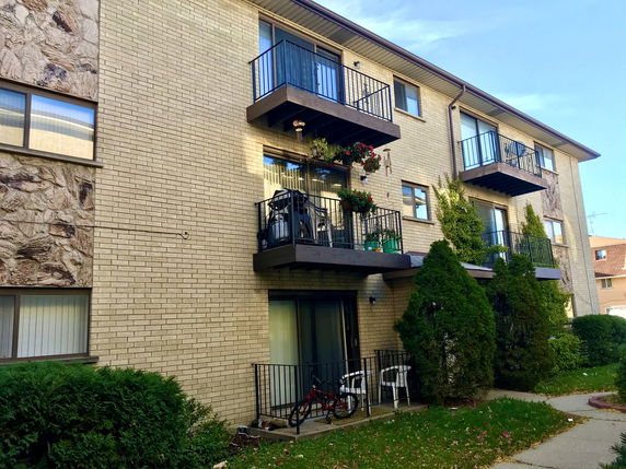 Front view of a multi-story apartment building with balconies.
