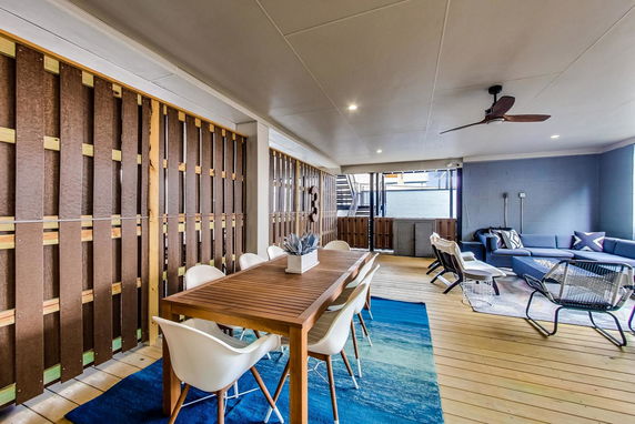 Interior view of a clubhouse with wooden flooring, a dining table, and seating area.