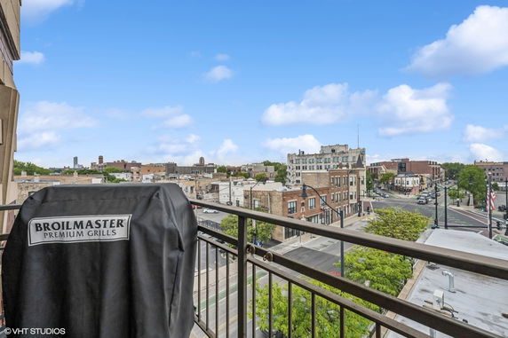 Panoramic view of surrounding urban neighborhood from a balcony with grill.