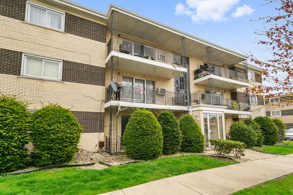 Front view of a three-story apartment building with balconies.