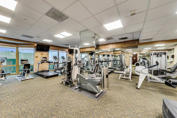 Indoor gym area with exercise equipment and mirrored walls.
