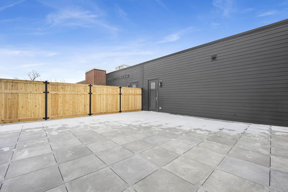 Rooftop area with fenced boundary and tiled flooring.