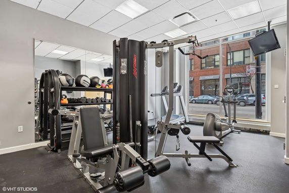 Indoor gym area with exercise equipment and large windows.