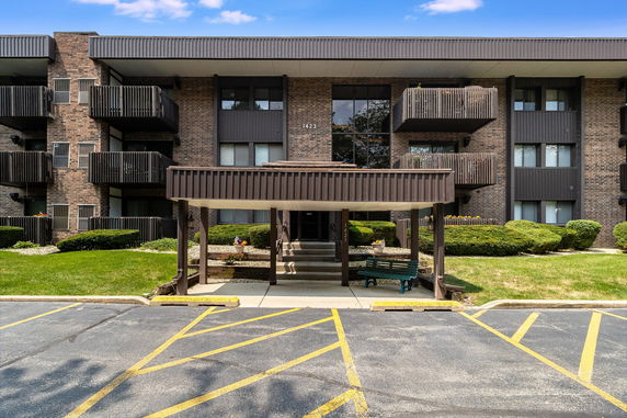 Front view of a multi-story building with balconies and a covered entrance.
