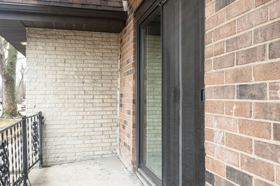 Exterior view of a brick wall with a sliding glass door.