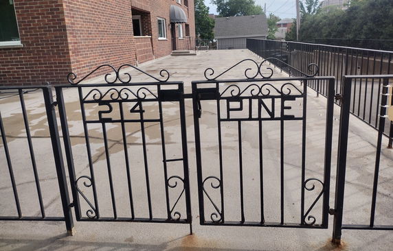 Entrance gate leading to the front view of a brick building.