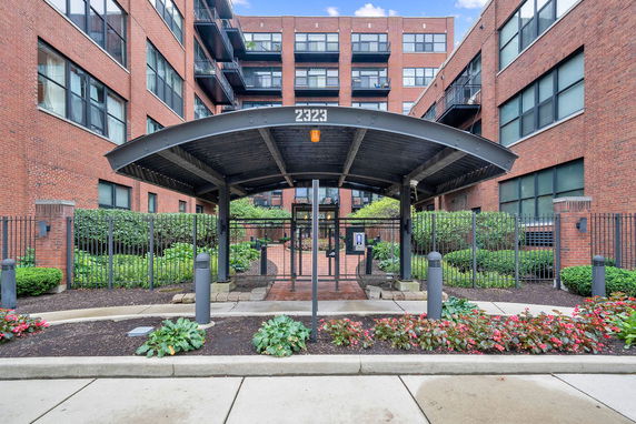 Front view of a multi-story brick building with a covered entrance.