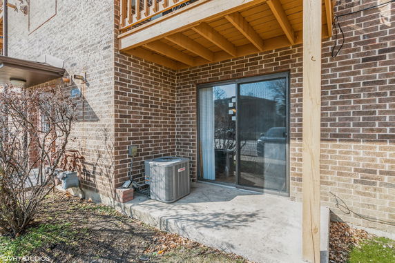 Rear view of a building with brick exterior and sliding glass door.