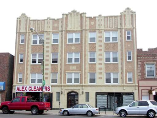 Front view of a multi-story building with a commercial property on the ground floor.