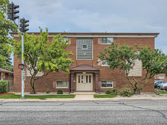 Front view of a two-story brick building with glass block windows and a central entrance.