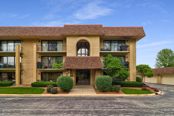 Front view of a multi-story building with balconies and a central entrance.