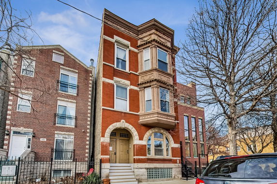 Front view of a three-story brick building with decorative elements
