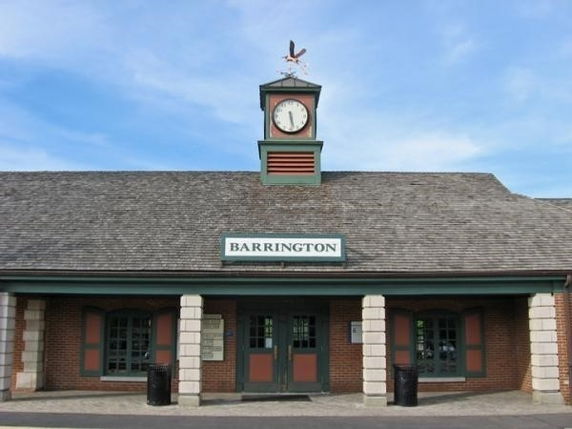 Front view of a building with a clock tower and sign reading 'Barrington.'