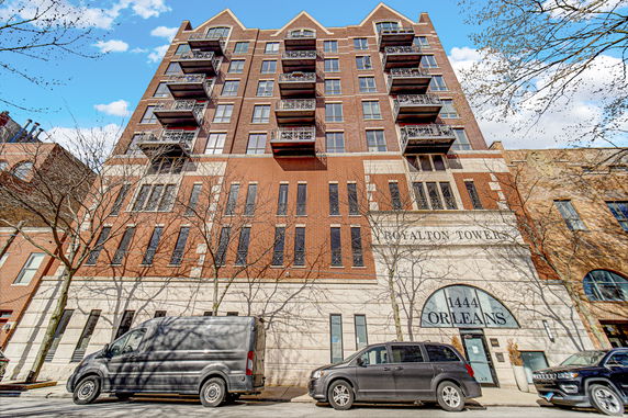 Front view of a multi-story brick building with balconies.