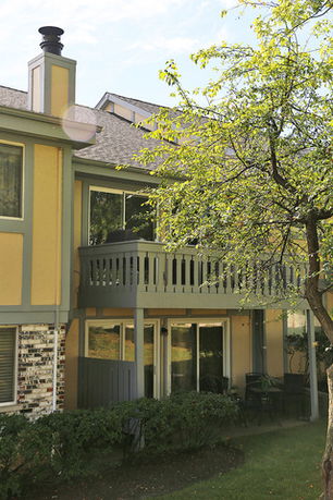 Front view of a two-story house with a balcony and chimney.