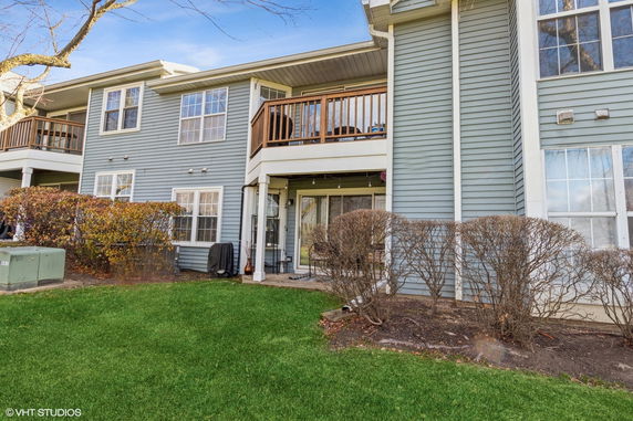 Front view of a two-story house with balconies and sliding doors.
