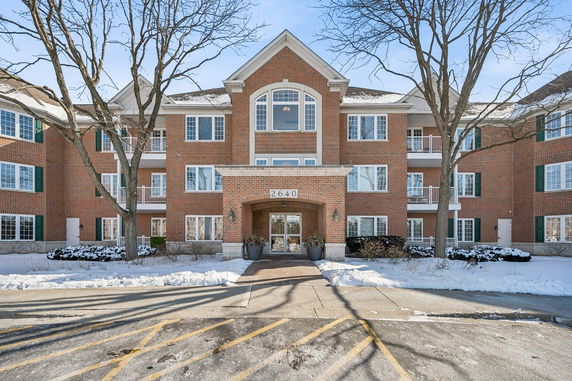Front view of a three-story brick building with multiple windows and an entrance.