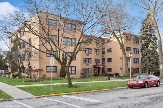 Front view of a multi-story brick apartment building.
