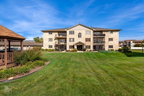Front view of a three-story building with balconies.