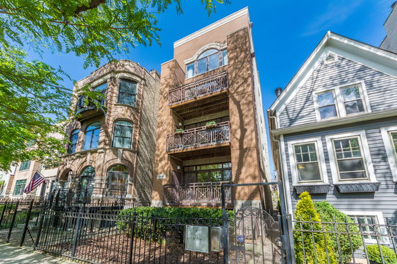 Front view of a multi-story brick building with balconies.