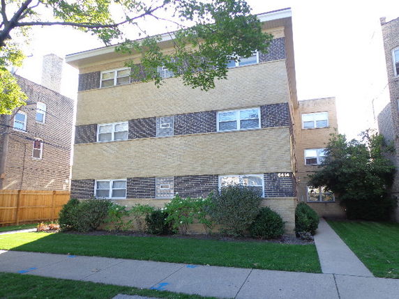 Front view of a three-story apartment building with brick façade.