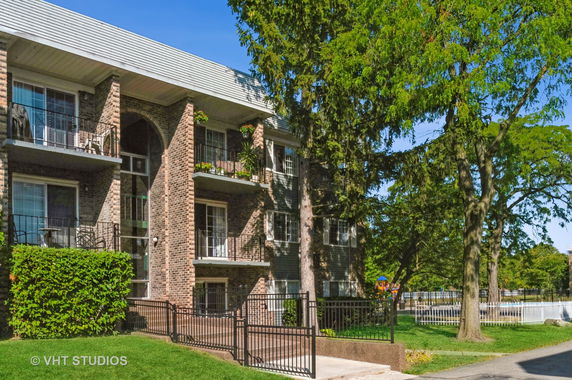 Front view of a multi-story residential building with balconies.