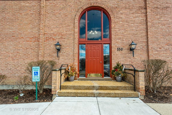 Front view of a building with red brick facade and arched red door entrance.