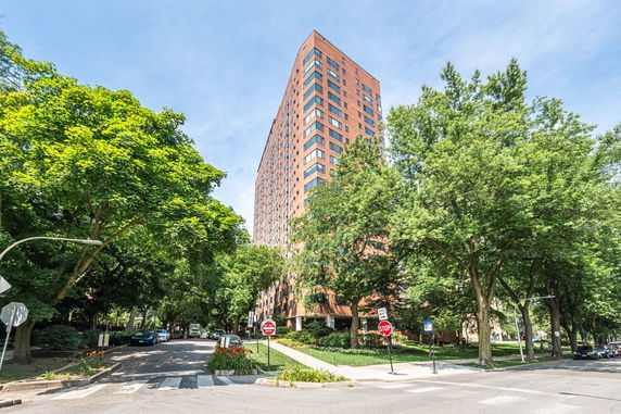 Front view of a tall brick residential building with rectangular windows.
