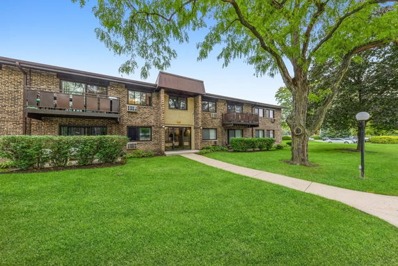 Front view of a two-story brick apartment building with balconies.