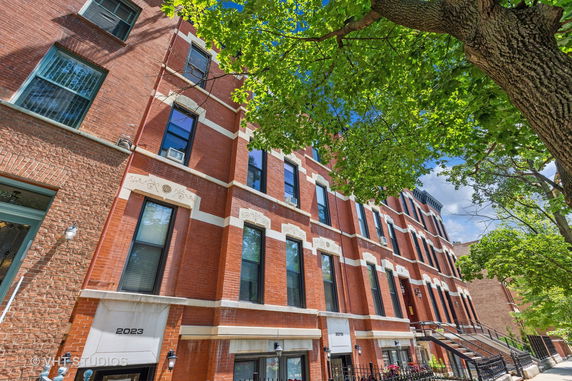 Front view of a brick multi-story urban residential building.