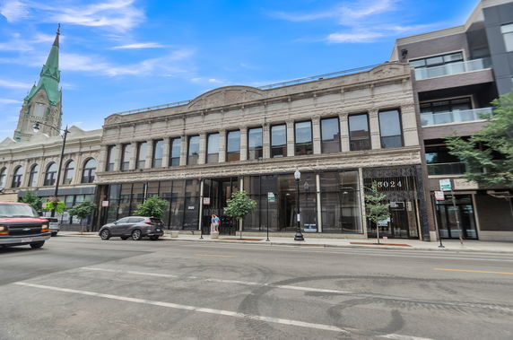 Front view of a two-story building with large windows and ornate architectural details.