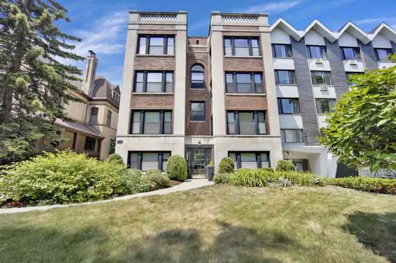 Front view of a multi-story apartment building with a brick facade.