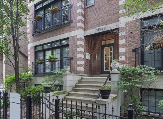 Front view of a multi-story brick building with steps leading to the entrance.