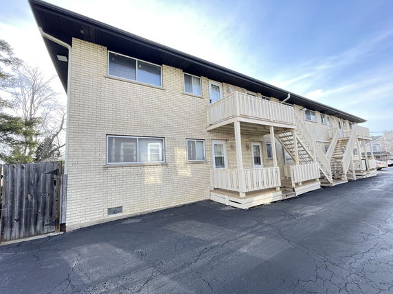 Front view of a two-story apartment building with exterior staircases and balconies.