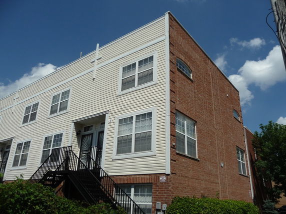 Front view of a two-story townhouse with brick and siding exterior.
