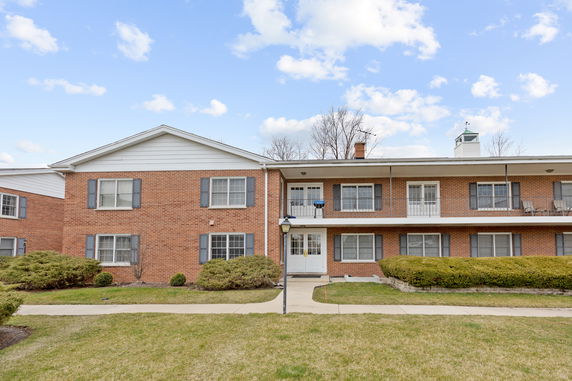 Front view of a two-story brick apartment building with balconies.