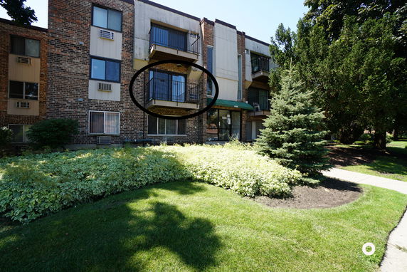 Front view of a multi-story apartment building with balconies.