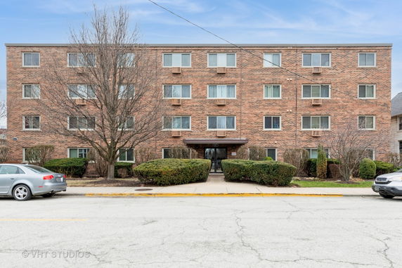 Front view of a four-story brick apartment building.