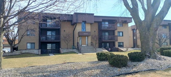 Front view of a three-story apartment building with balconies.