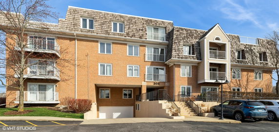 Front view of a multistory building with brick exterior and balconies.