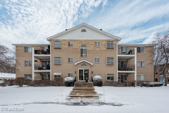 Front view of a three-story apartment building with a central entrance.