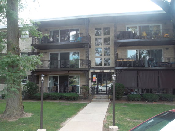 Front view of a multi-story apartment building with balconies.